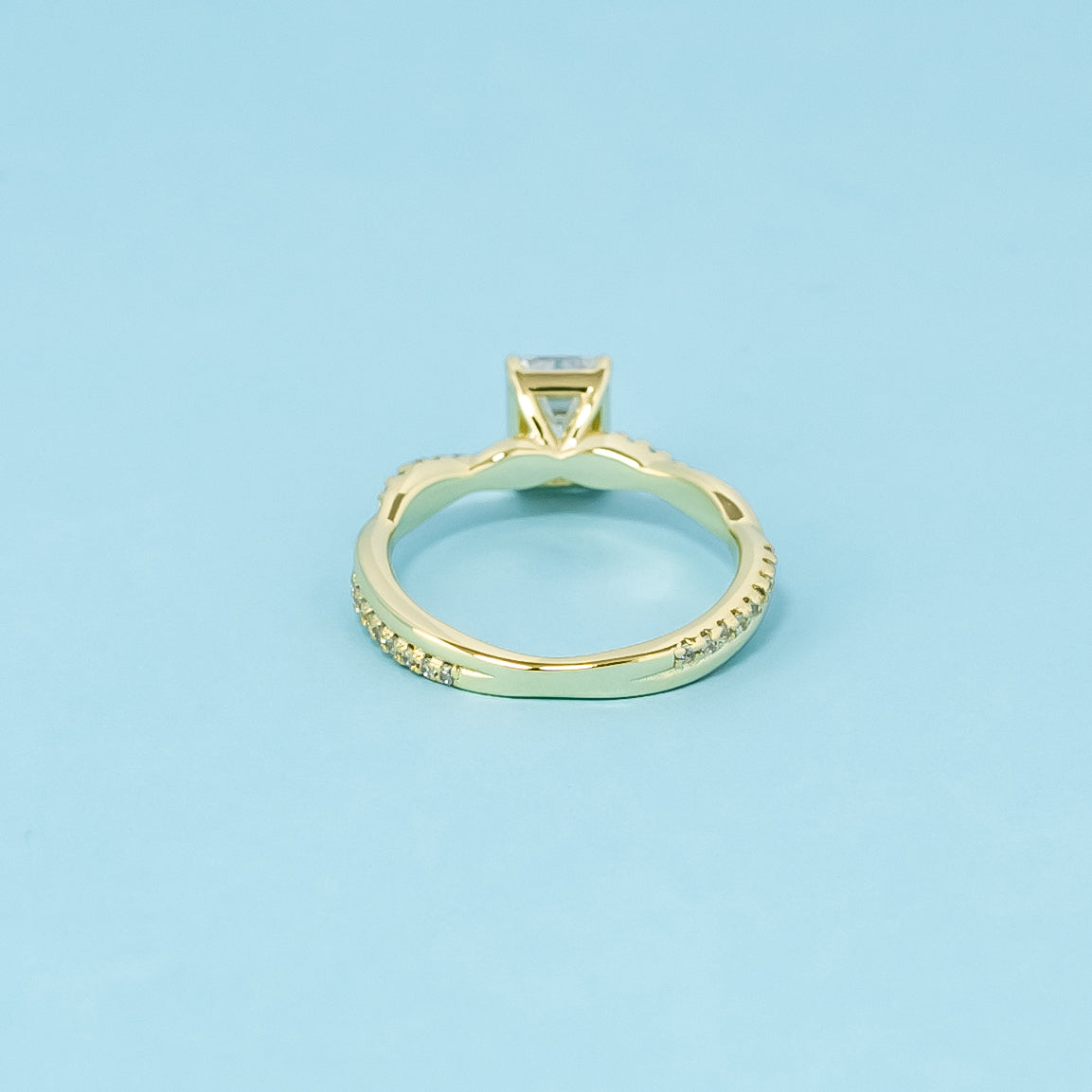 A beautiful symbol of everlasting love, this 9ct yellow gold ring features an emerald cut moissanite and a continuous infinity design.