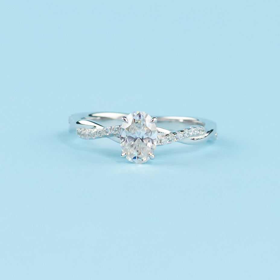 A beautiful oval cut moissanite engagement ring set in a delicate 9ct white gold band with an infinity design.