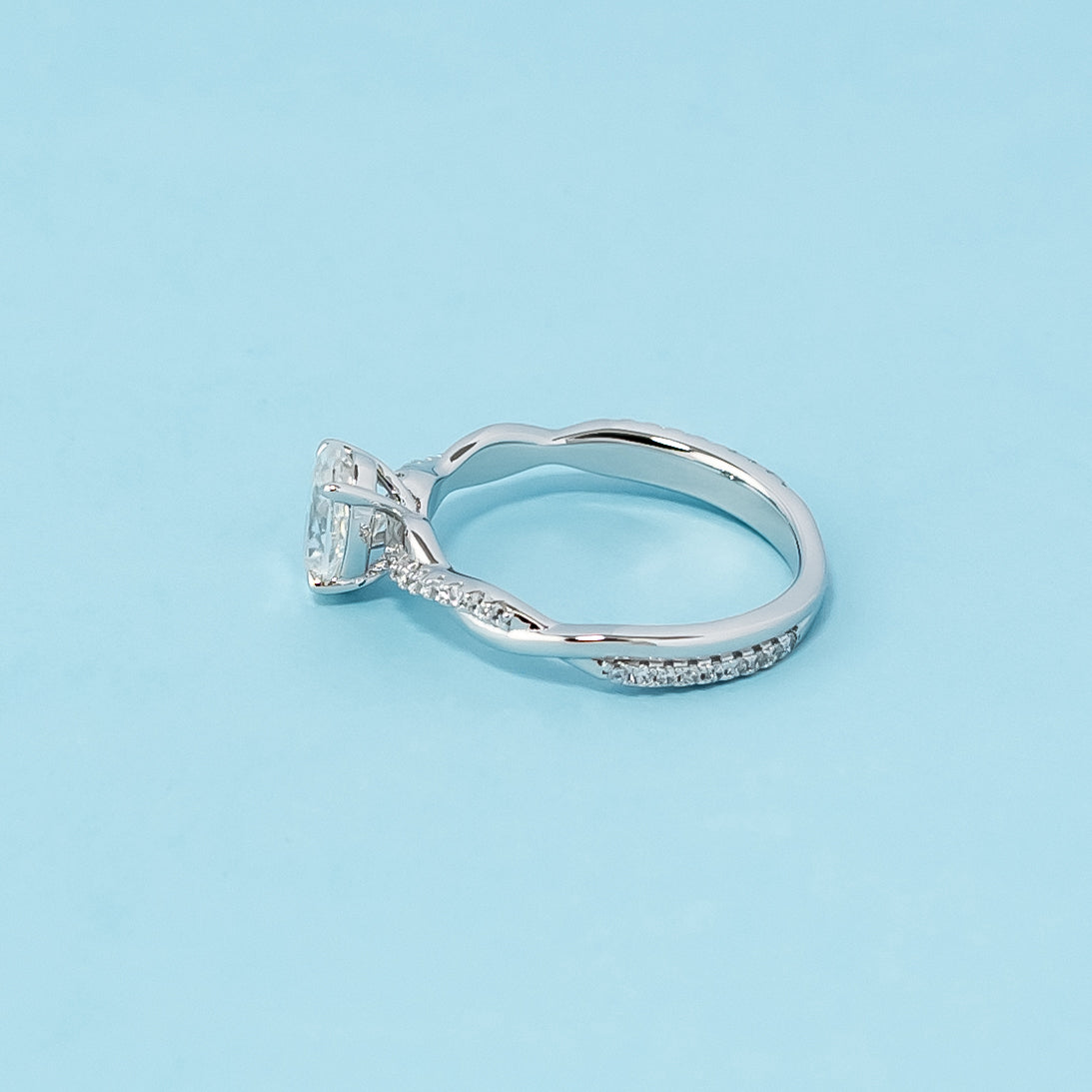 This 9ct white gold engagement ring showcases a sparkling oval cut moissanite within a timeless infinity setting, representing eternal commitment.