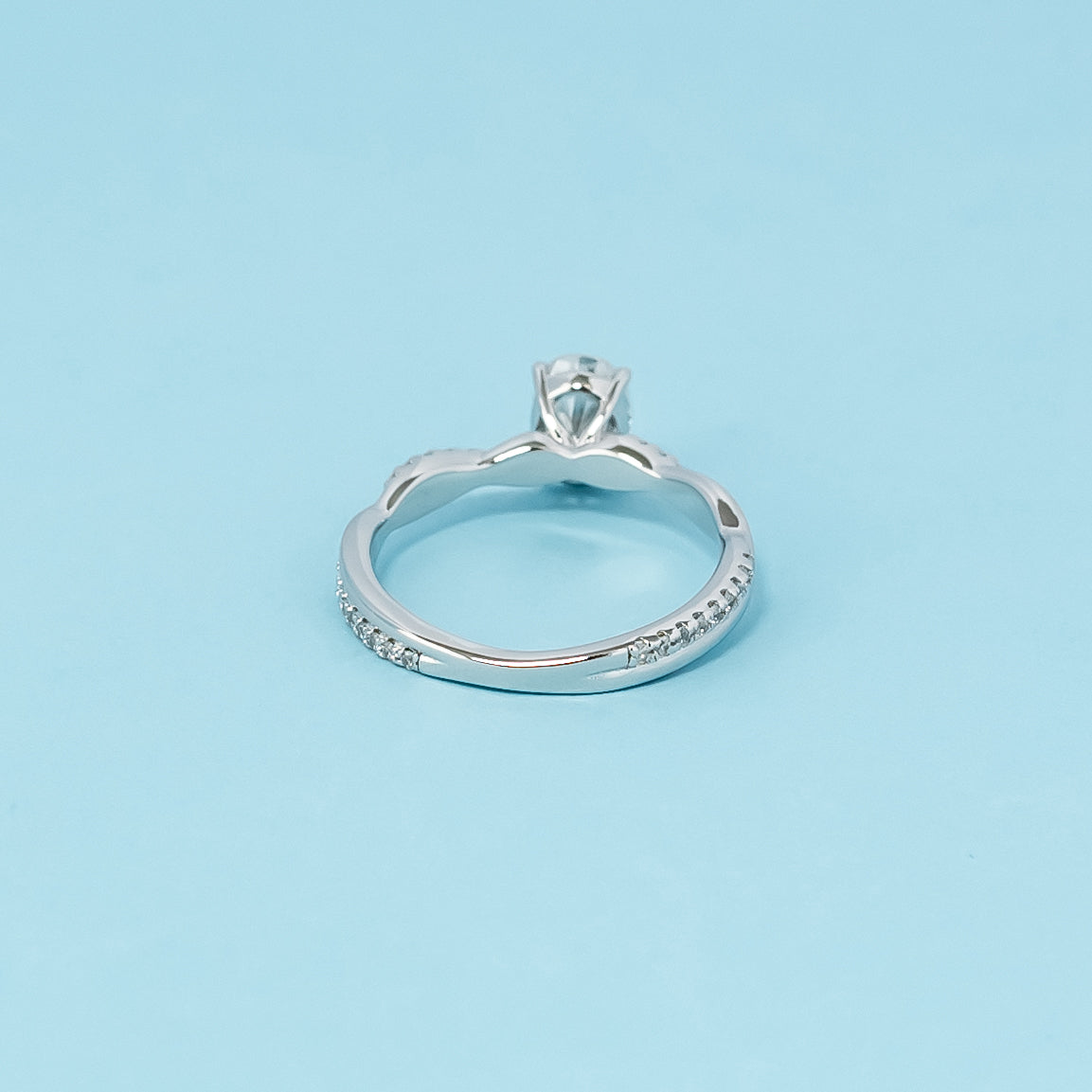 A sophisticated engagement ring combining the brilliance of an oval cut moissanite with the symbolic design of an infinity band, crafted in 9ct white gold.