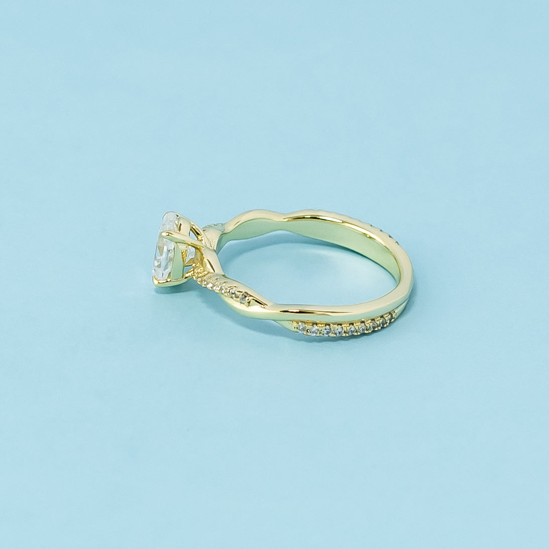 This 9ct yellow gold ring features a classic oval cut moissanite with a delicate infinity design element.