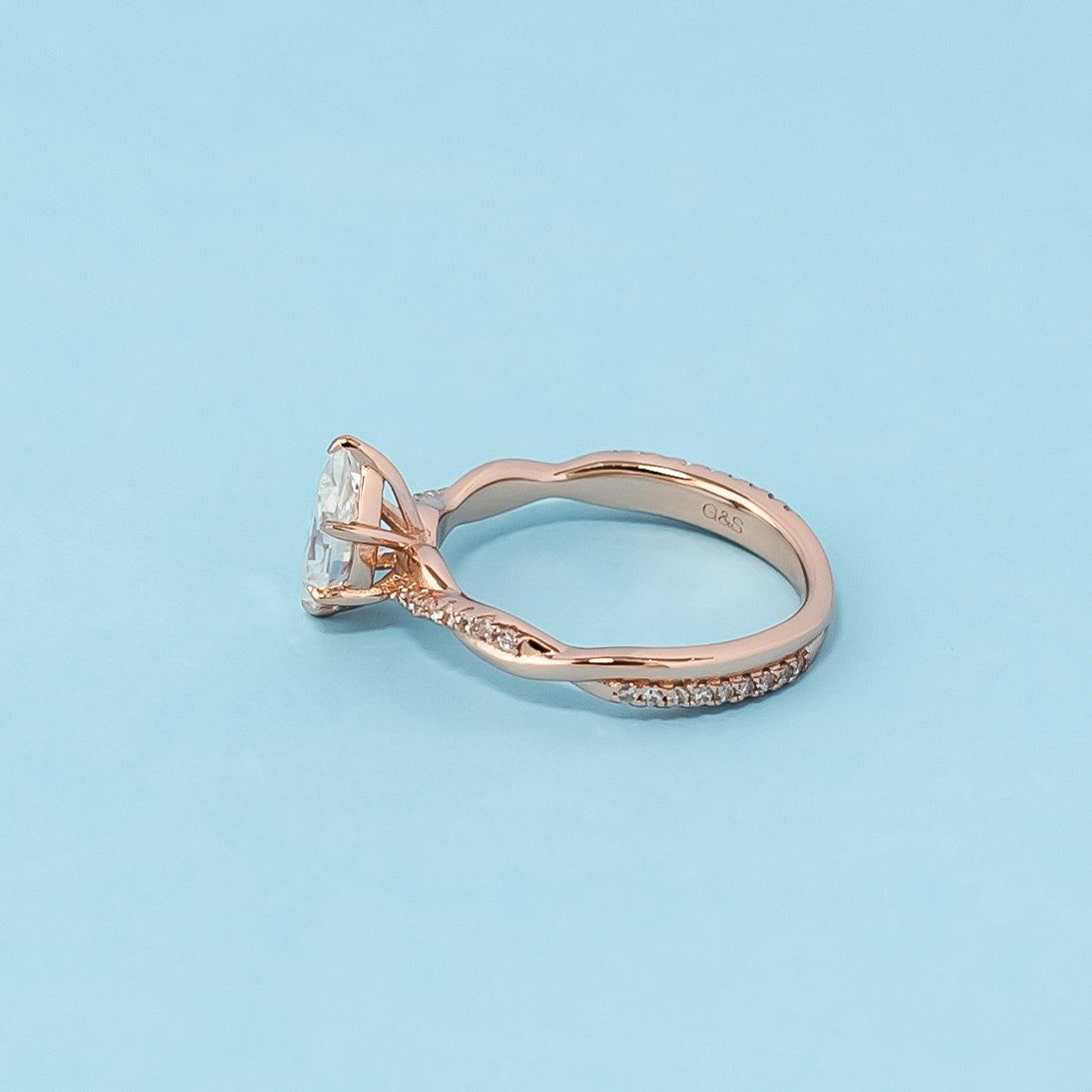 Stunning rose gold engagement ring featuring a sparkling pear-shaped moissanite in a classic infinity design.