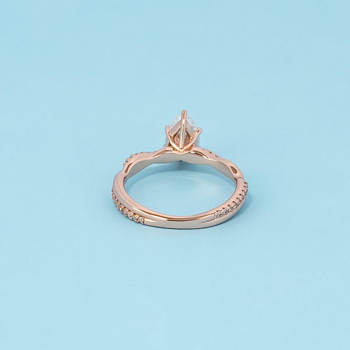 Luxurious 9ct rose gold engagement ring showcasing a beautiful pear-shaped moissanite in a timeless infinity setting.