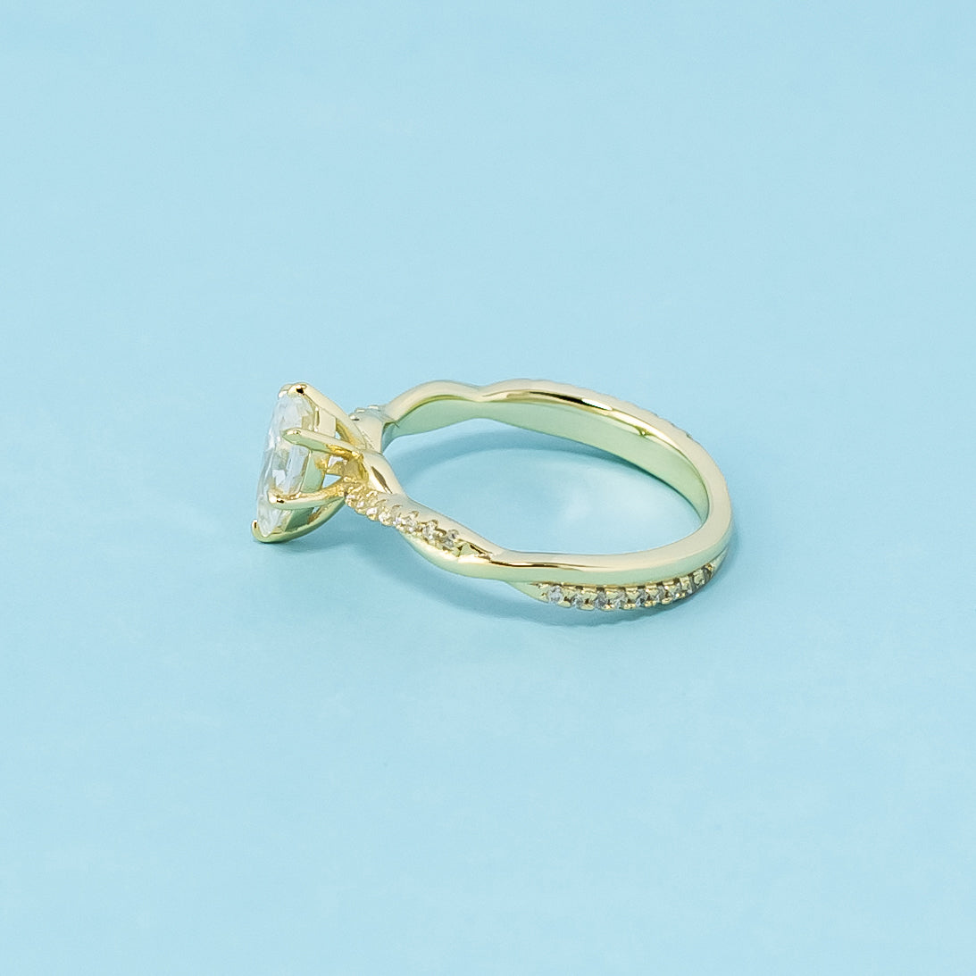 This 9ct yellow gold ring features a classic pear cut moissanite with a delicate infinity design element.