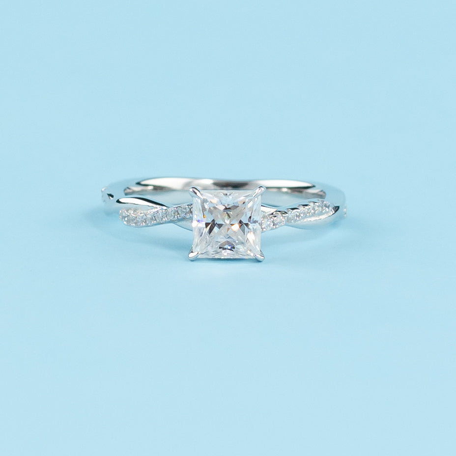 Elegant 9ct white gold engagement ring featuring a princess cut moissanite in a timeless infinity design.