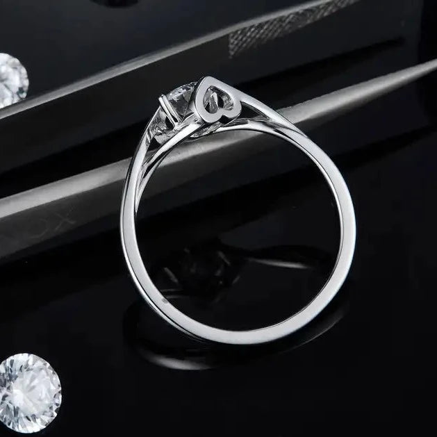 This enchanting ring features a 0.50ct moissanite center stone and a unique two-heart design, all beautifully crafted in sterling silver.