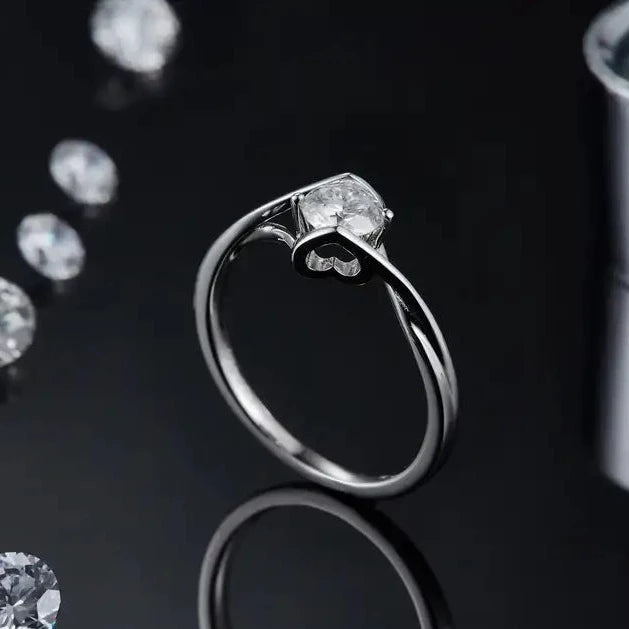 A timeless and romantic engagement ring showcasing a 0.50ct moissanite held by a delicate two-heart design, crafted from high-quality sterling silver.