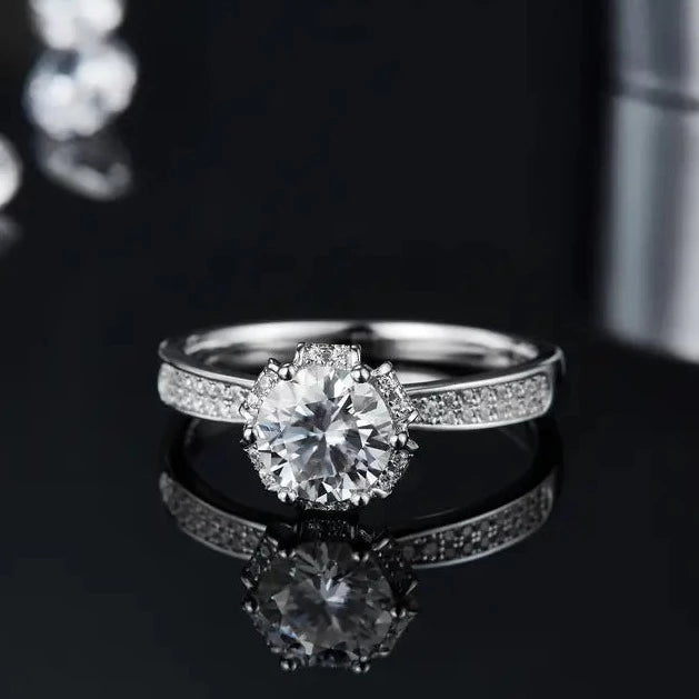 This elegant engagement ring features a 1.00ct moissanite center stone, complemented by pave-set moissanites in a vintage-inspired sterling silver setting.
