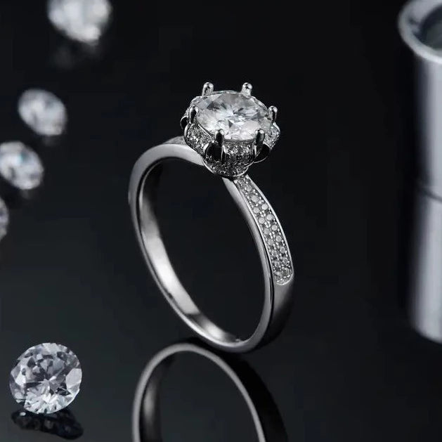 A detailed sterling silver engagement ring featuring a 1.00ct moissanite center stone with an intricate vintage pave design that adds a touch of timeless elegance.