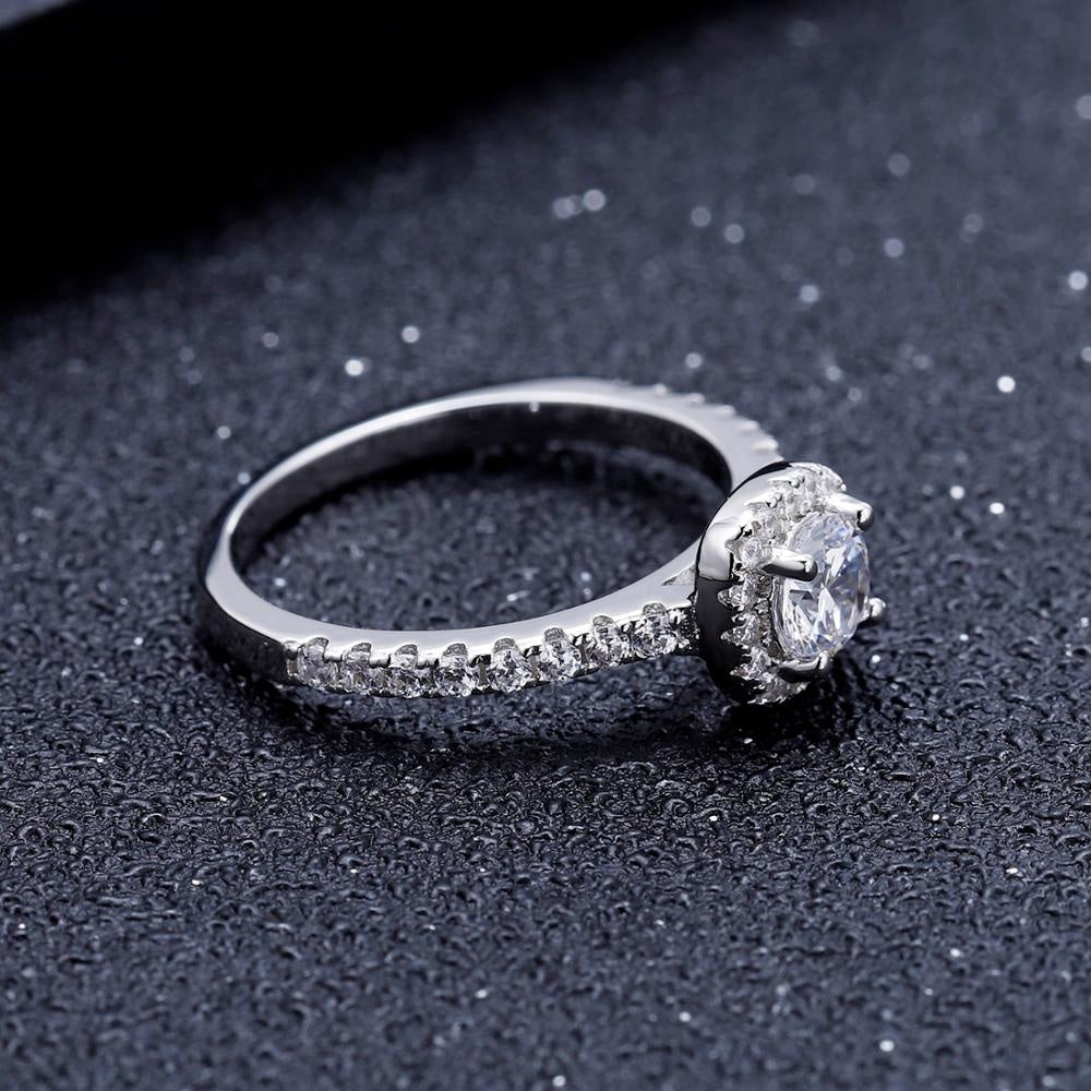 A beautiful halo design accentuates the brilliance of a 0.50ct moissanite in this sterling silver ring.