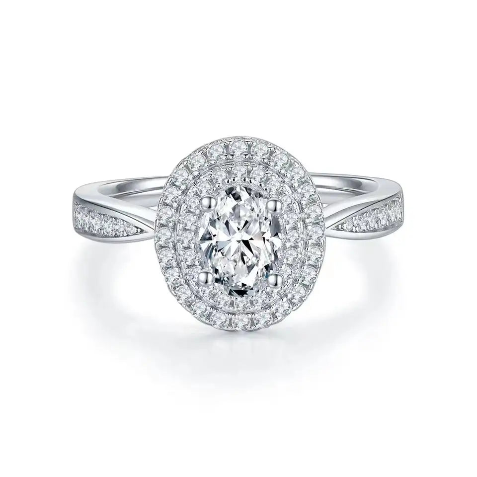 This ring showcases a brilliant oval moissanite center stone, encircled by a double halo design for maximum sparkle.