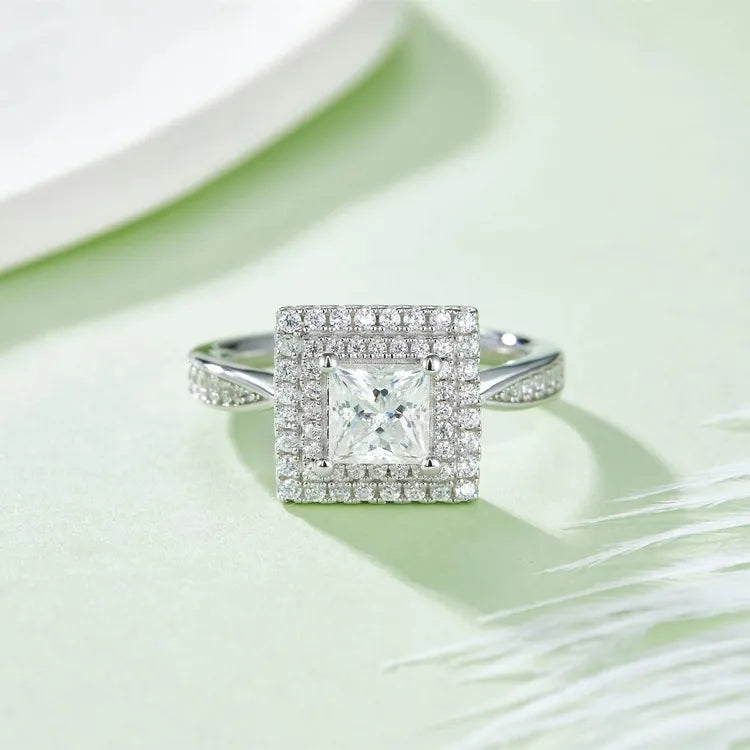 An exquisite engagement ring with a 1.00ct princess cut moissanite and an intricate double halo design, offering exceptional sparkle and elegance.