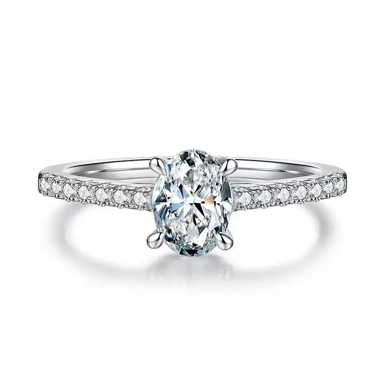 Profile view of an oval cut moissanite engagement ring, highlighting the delicate basket setting that securely holds the 1.00ct center stone.