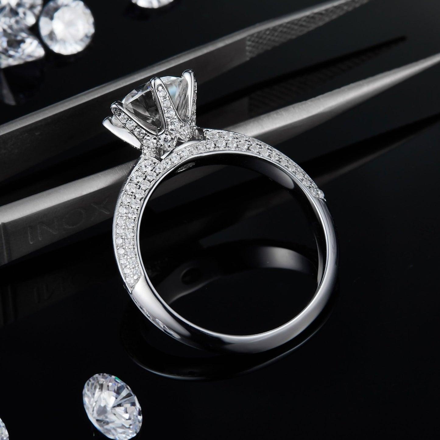 This elegant ring features a sizable 2.00ct moissanite and intricate pave detailing on the band for a refined and glamorous appearance.