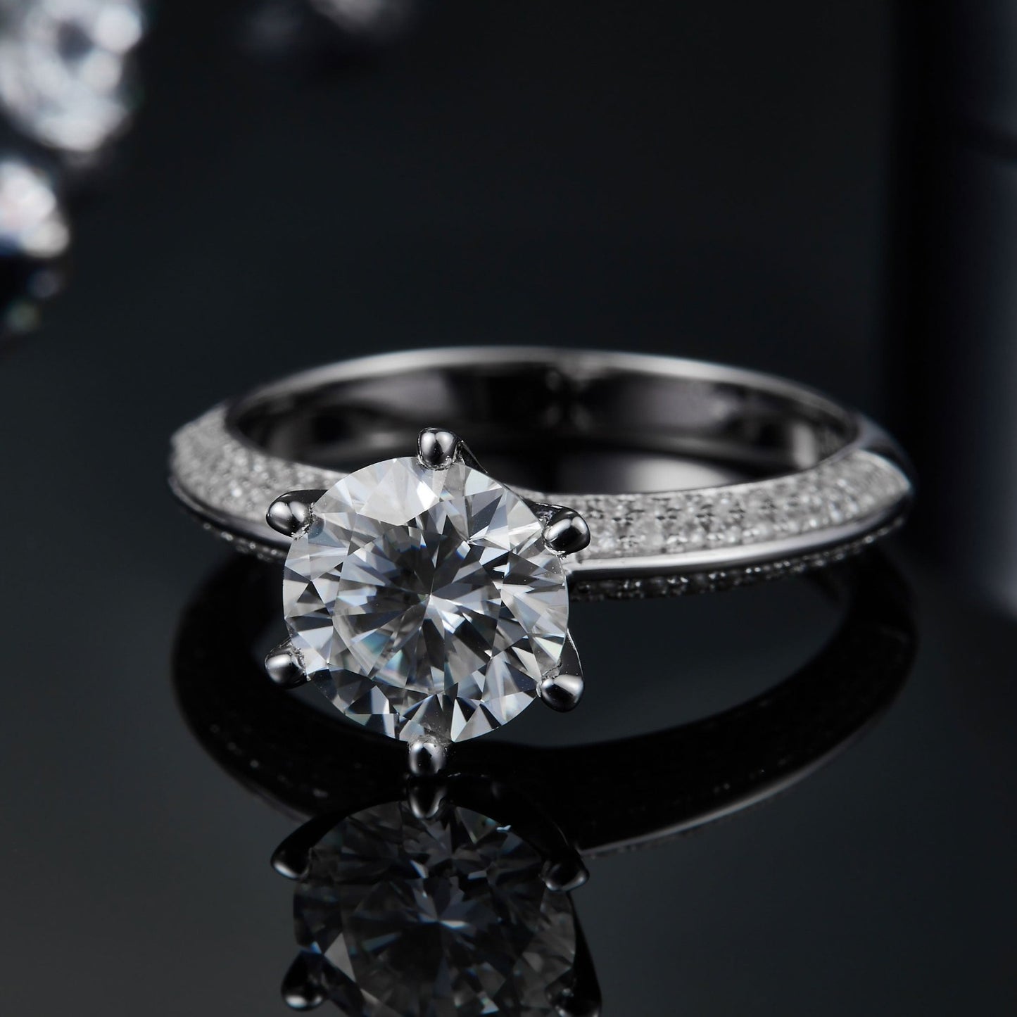 A beautifully crafted engagement ring featuring a prominent 2.00ct moissanite and a band encrusted with pave-set stones, offering exceptional sparkle and sophistication.