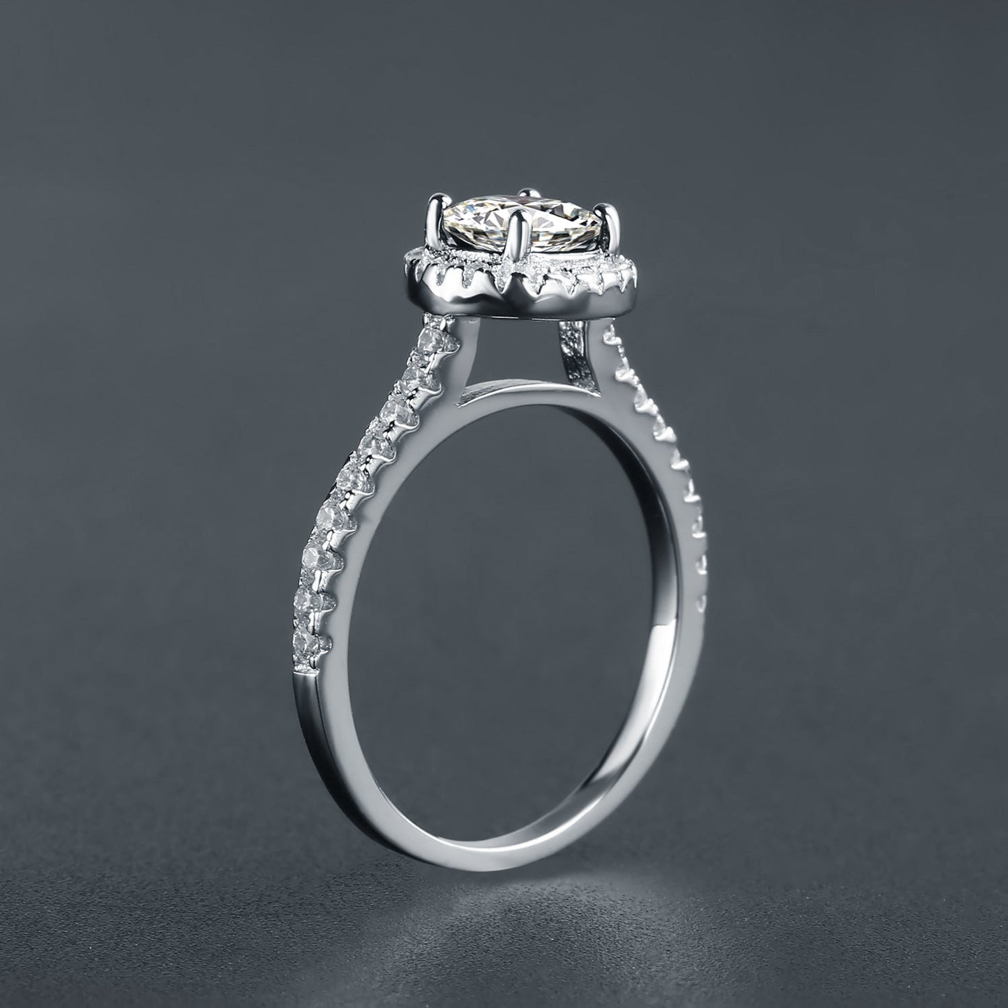A captivating engagement ring featuring a brilliant oval moissanite encircled by a halo of shimmering stones, set in a beautiful 9ct white gold band.