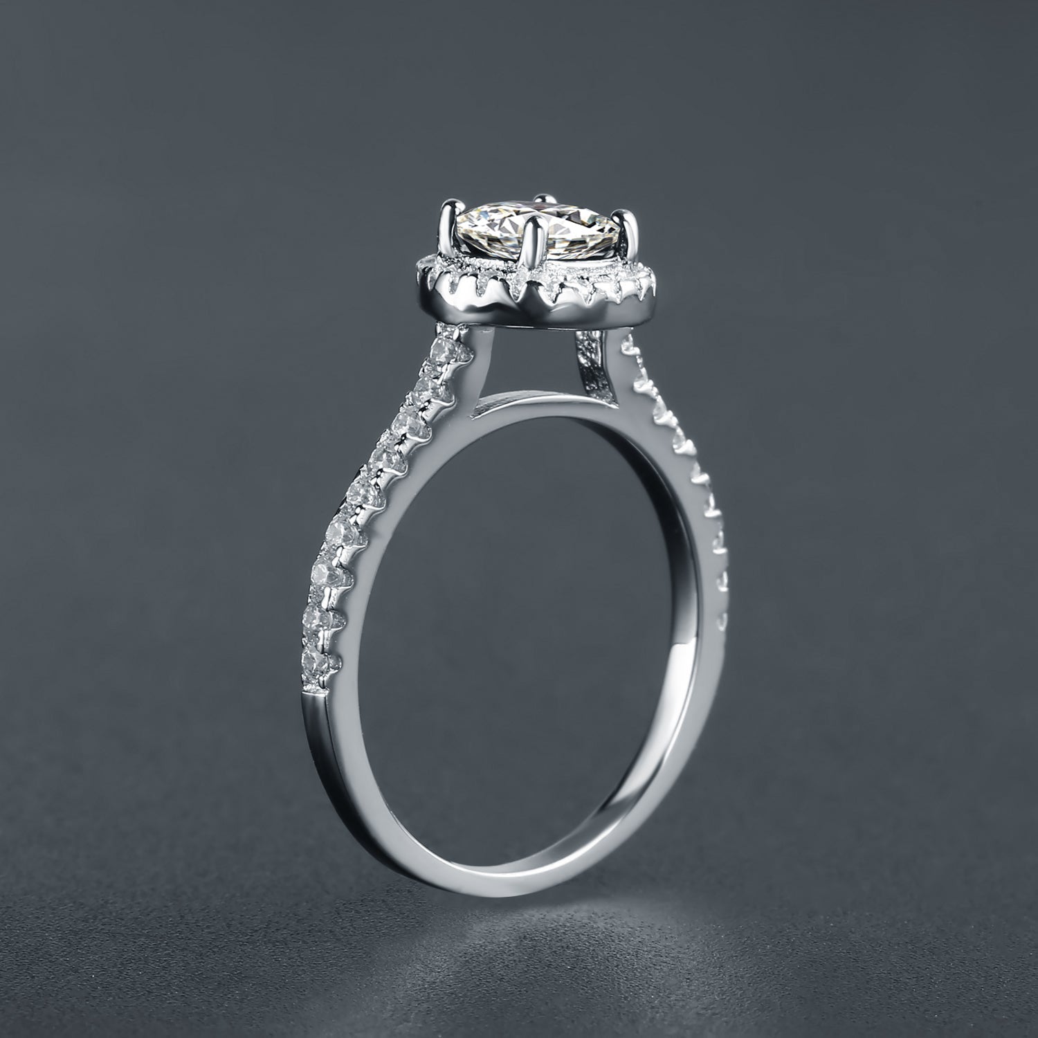 A captivating engagement ring featuring a brilliant oval moissanite encircled by a halo of shimmering stones, set in a beautiful 9ct white gold band.