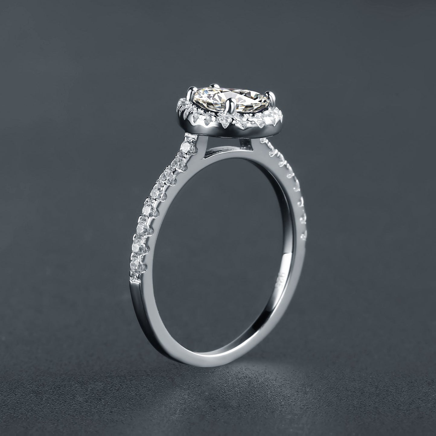A captivating engagement ring featuring a brilliant pear-shaped moissanite encircled by a halo of shimmering stones, set in a beautiful 9ct white gold band.