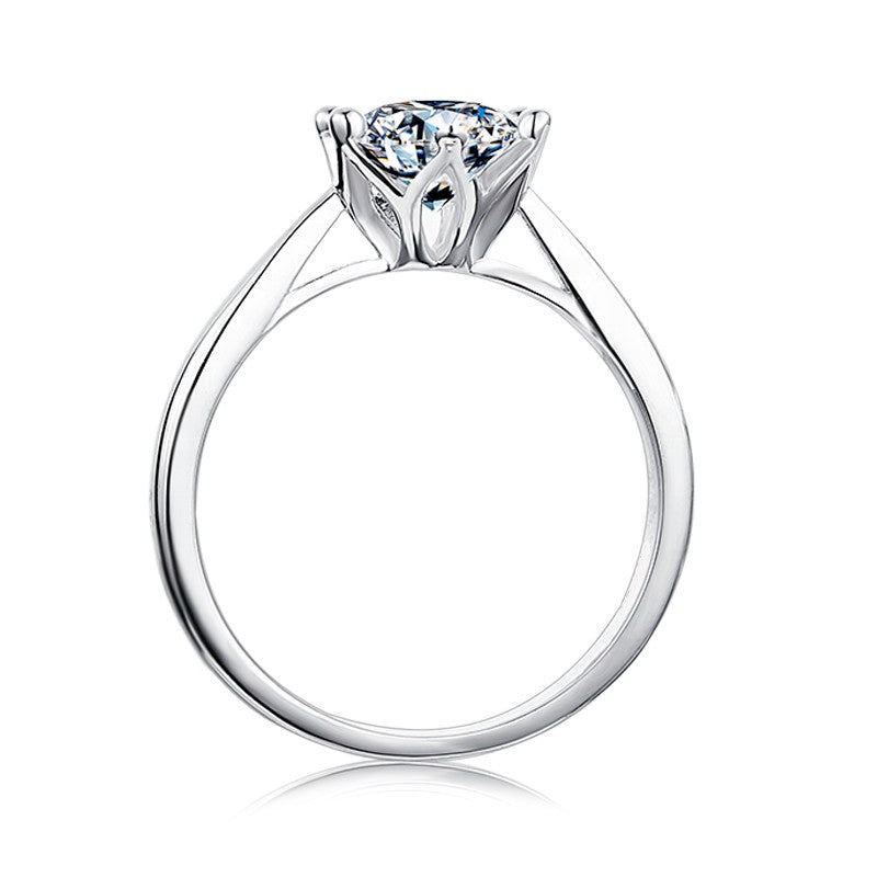 A 1.00ct moissanite takes center stage in this enchanting 6-claw setting with a delicate floral basket design, crafted in 9ct white gold.