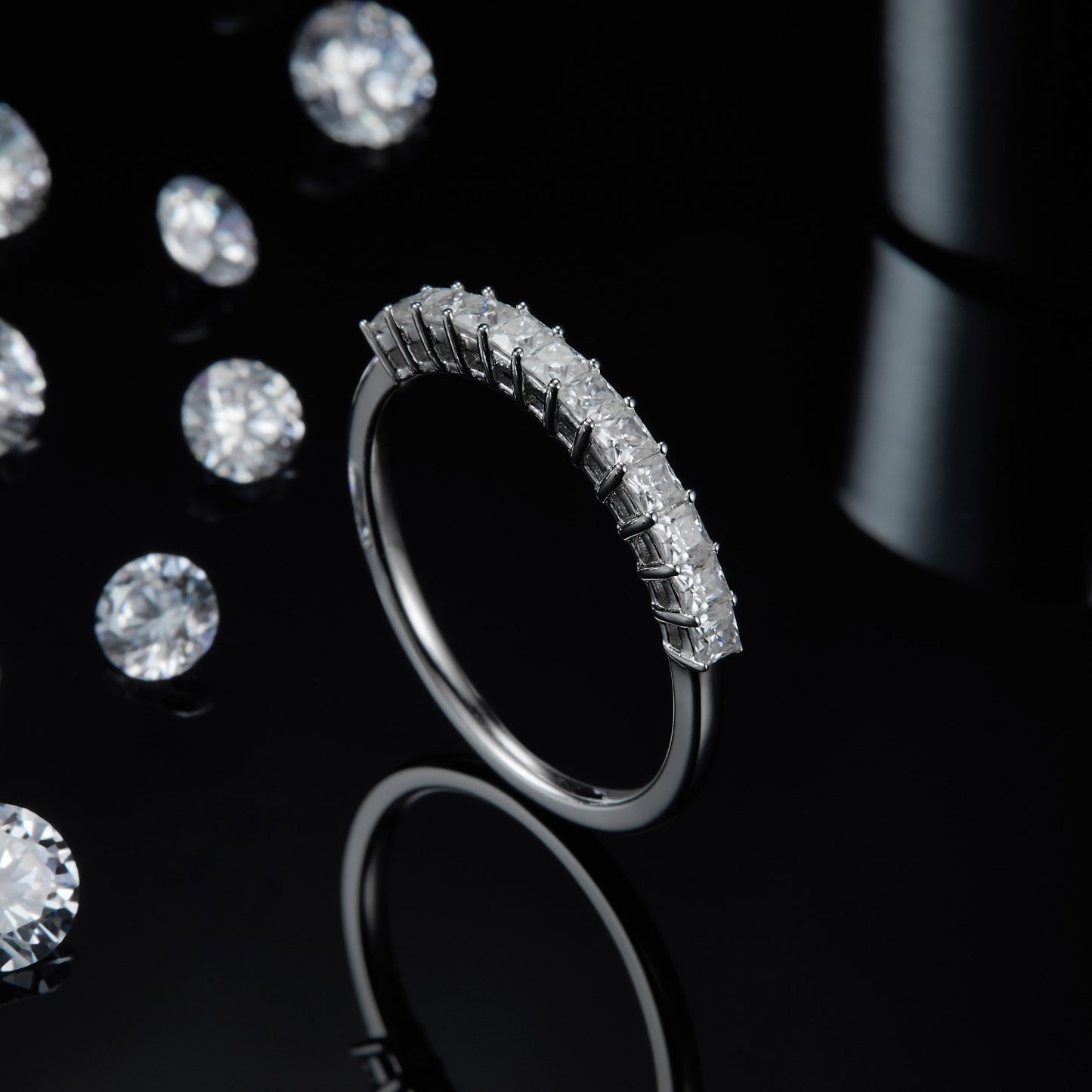 A contemporary wedding band set crafted in sterling silver and featuring the geometric brilliance of square cut moissanites in a half eternity arrangement.