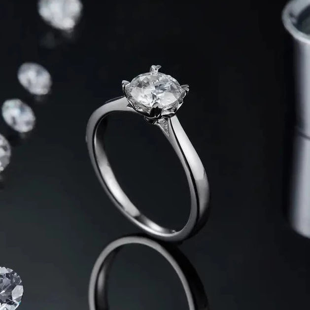 Experience timeless elegance with this 1.00ct moissanite engagement ring, featuring a classic 4-prong setting with heart-shaped claws.