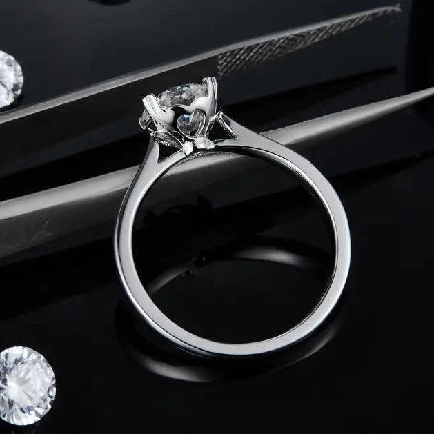 A classic solitaire design with a charming twist, featuring a 1.00ct moissanite set with heart-shaped details on a sterling silver band.
