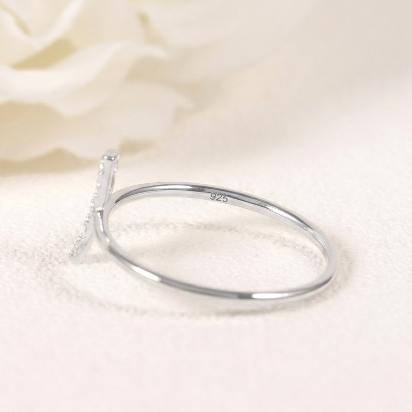 Silver ring with a small diamond on a beige fabric background
