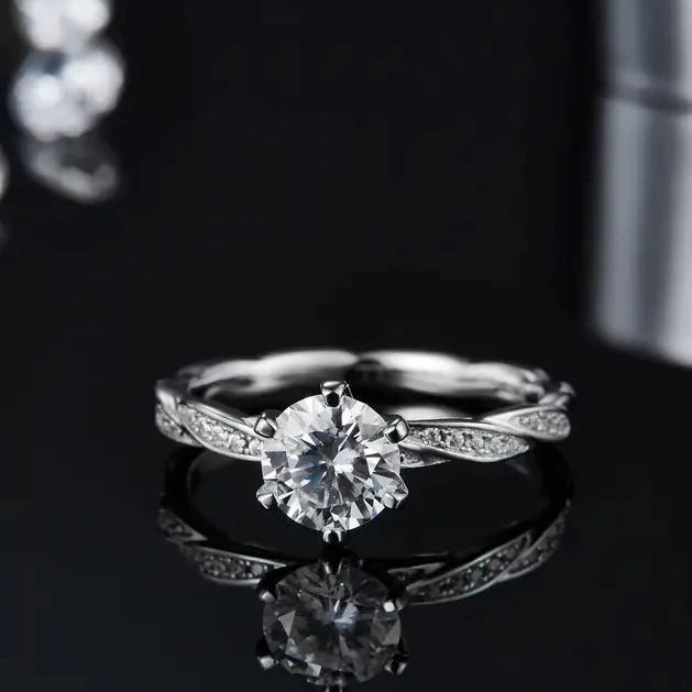 A sterling silver engagement ring set exuding antique charm, featuring a 1.00ct moissanite and intricate vintage patterns.