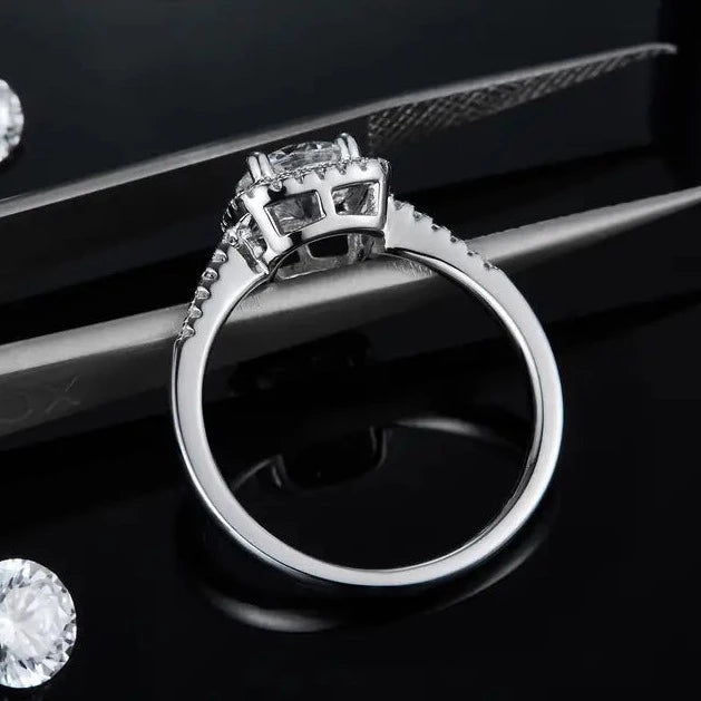 Close-up view of the sparkling 1.00ct moissanite center stone and the surrounding halo of stones, set in a sterling silver band.