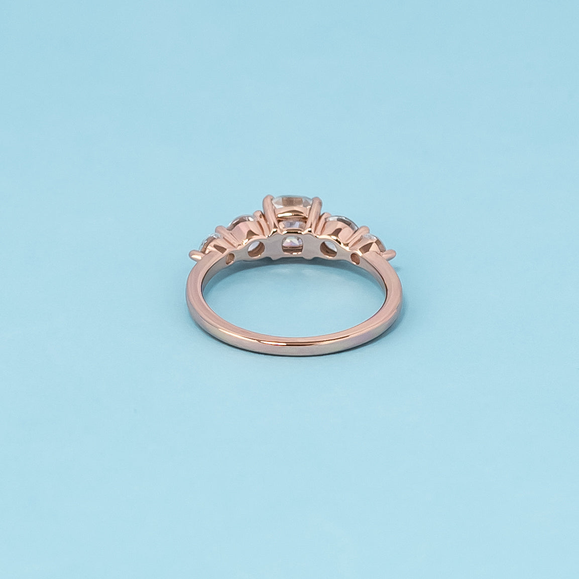 Luxurious 9ct rose gold engagement ring set with five beautiful cushion cut moissanites, symbolizing enduring love and brilliance.