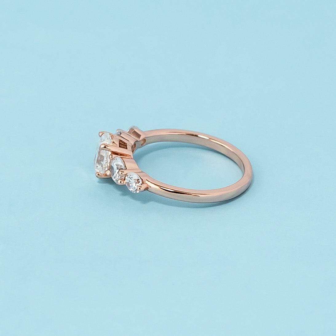 Elegant rose gold engagement ring showcasing five sparkling oval cut moissanites in a classic design.