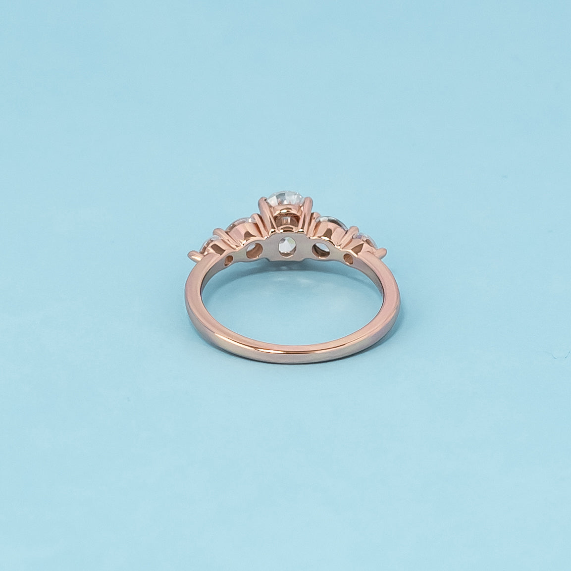 Luxurious 9ct rose gold engagement ring set with five beautiful oval cut moissanites, symbolizing enduring love and brilliance.