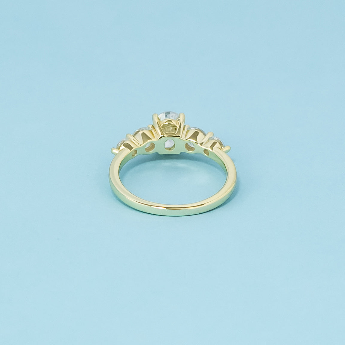 This 9ct yellow gold engagement ring features five dazzling oval moissanites, symbolizing everlasting brilliance and unity.
