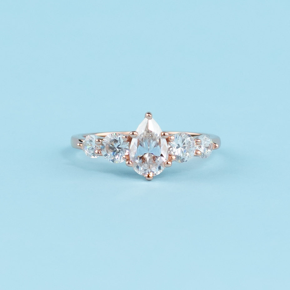 Stunning five-stone engagement ring featuring pear-shaped moissanites, set in warm 9ct rose gold for eternal brilliance.