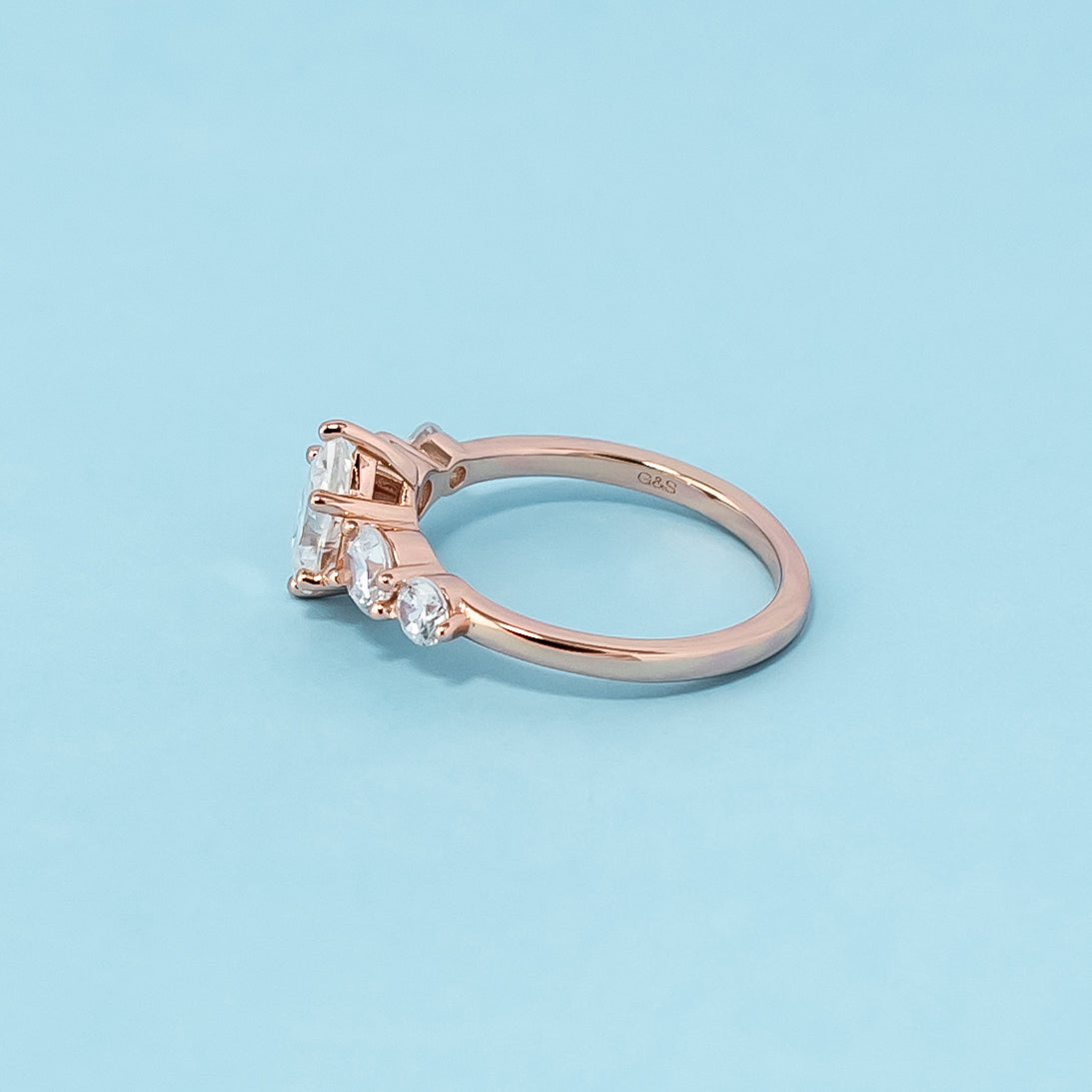 Elegant rose gold engagement ring showcasing five sparkling pear-shaped moissanites in a classic design.