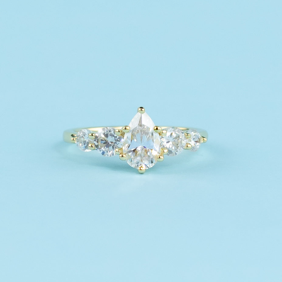 Showcases five sparkling pear-shaped moissanites in a warm 9ct yellow gold setting.