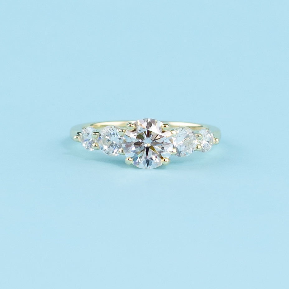 This elegant ring showcases five brilliant round moissanites, representing a lifetime of brilliance.