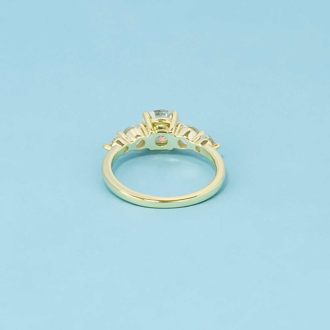 This 9ct yellow gold engagement ring features five brilliant round moissanites, representing everlasting elegance and sparkle.