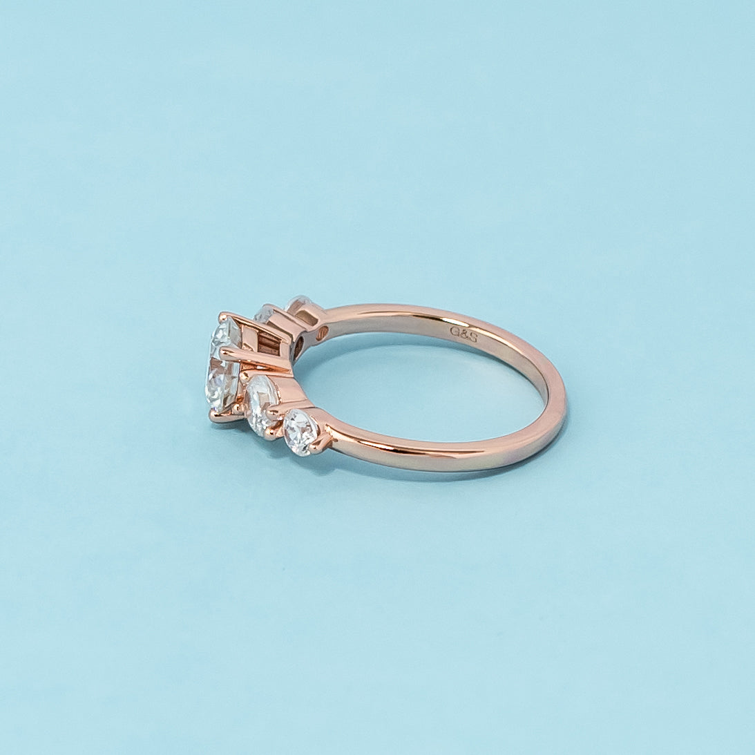 Elegant rose gold engagement ring showcasing five sparkling round brilliant moissanites in a classic design.
