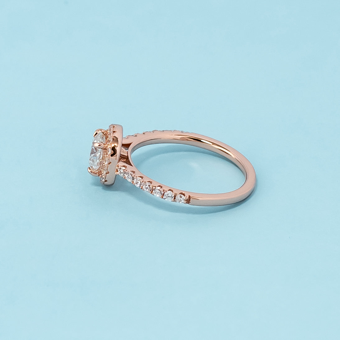 Stunning rose gold engagement ring showcasing a sparkling cushion cut moissanite surrounded by a dazzling halo.