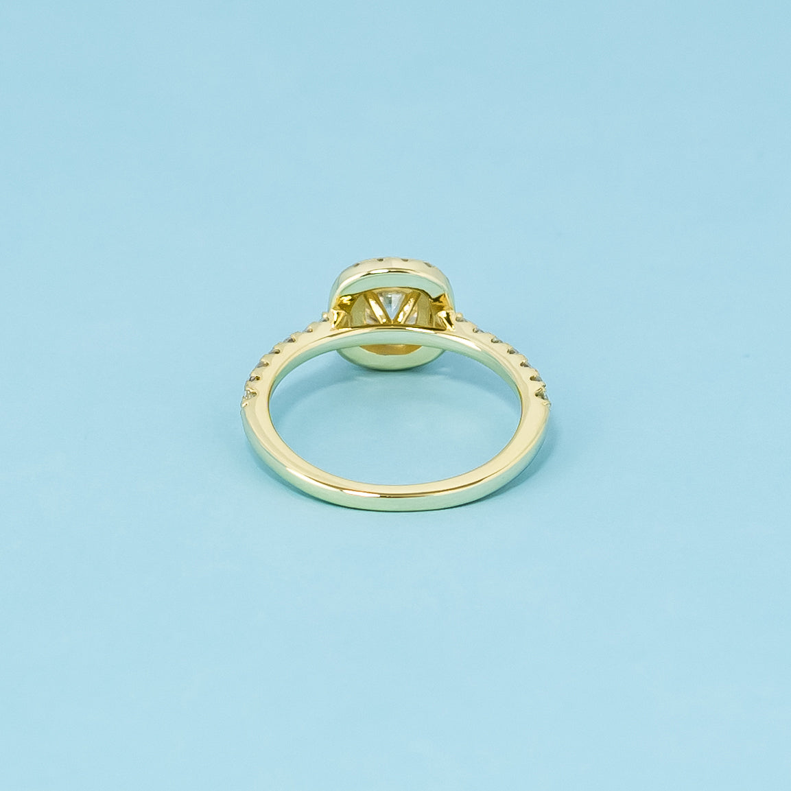 This elegant 9ct yellow gold ring features a cushion cut moissanite with a classic halo, creating a beautiful and enduring engagement ring.
