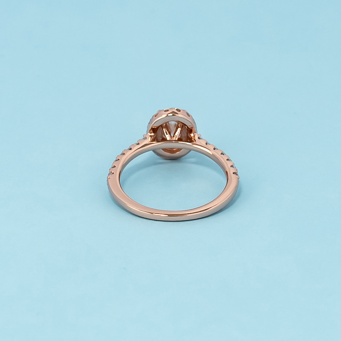 Timeless and luxurious 9ct rose gold engagement ring showcasing a beautiful oval cut moissanite with a classic halo design.