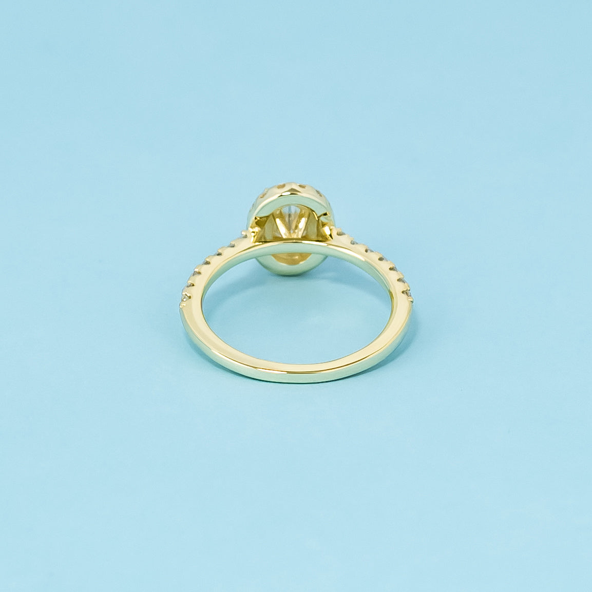 This elegant 9ct yellow gold ring features an oval cut moissanite with a classic halo, creating a beautiful and enduring engagement ring.