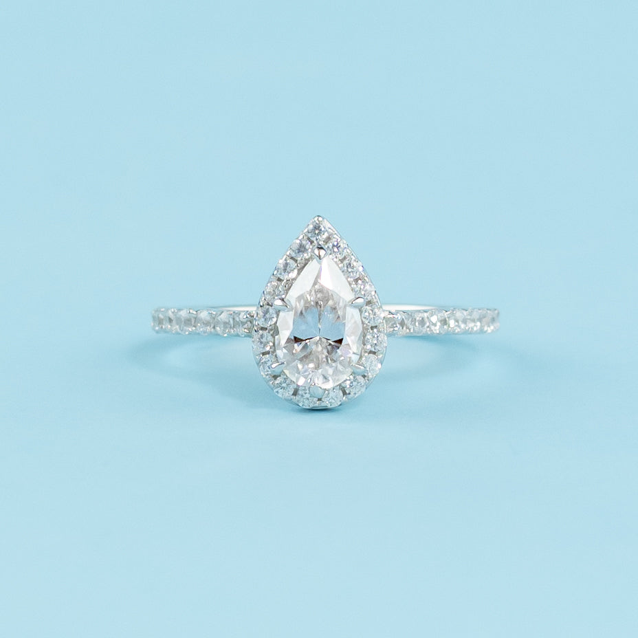 Elegant 9ct white gold engagement ring featuring a pear-shaped moissanite surrounded by a classic halo setting.