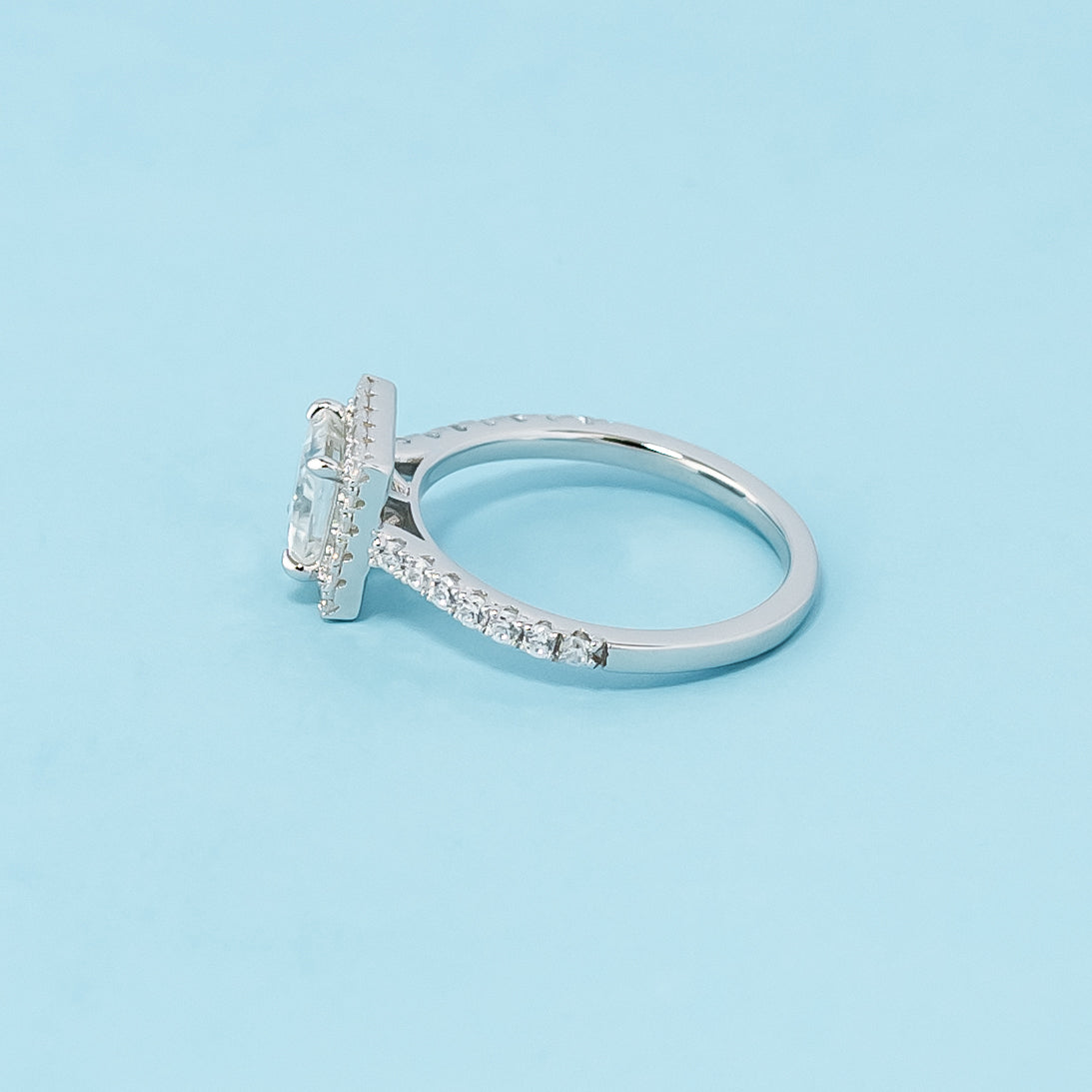 Timeless and sophisticated engagement ring showcasing a princess cut moissanite in a beautiful halo design, crafted in 9ct white gold.