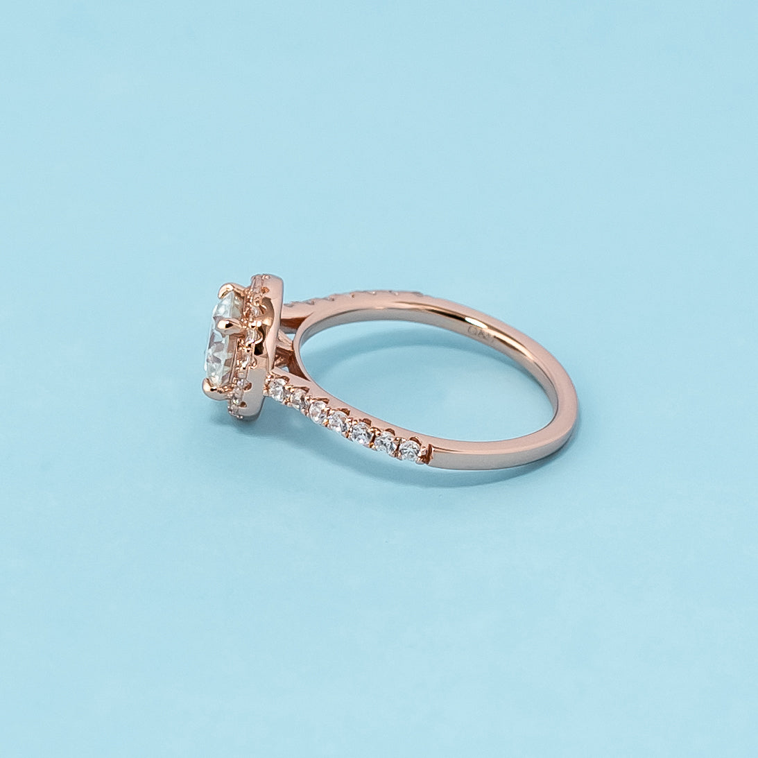 Stunning rose gold engagement ring showcasing a sparkling round brilliant moissanite encircled by a dazzling halo.