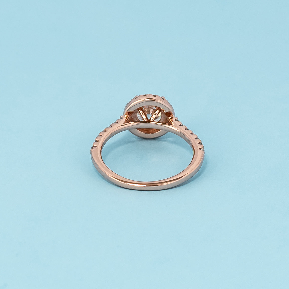 Timeless and luxurious 9ct rose gold engagement ring featuring a beautiful round brilliant moissanite in a classic halo design.