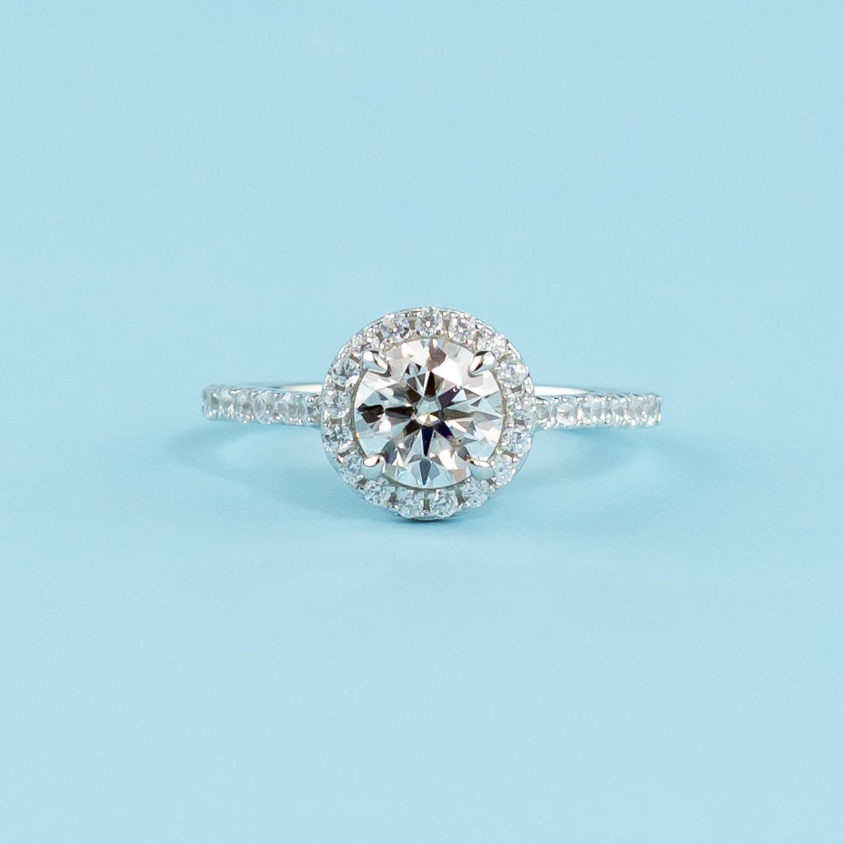 Elegant 9ct white gold engagement ring featuring a round brilliant moissanite encircled by a classic halo setting.