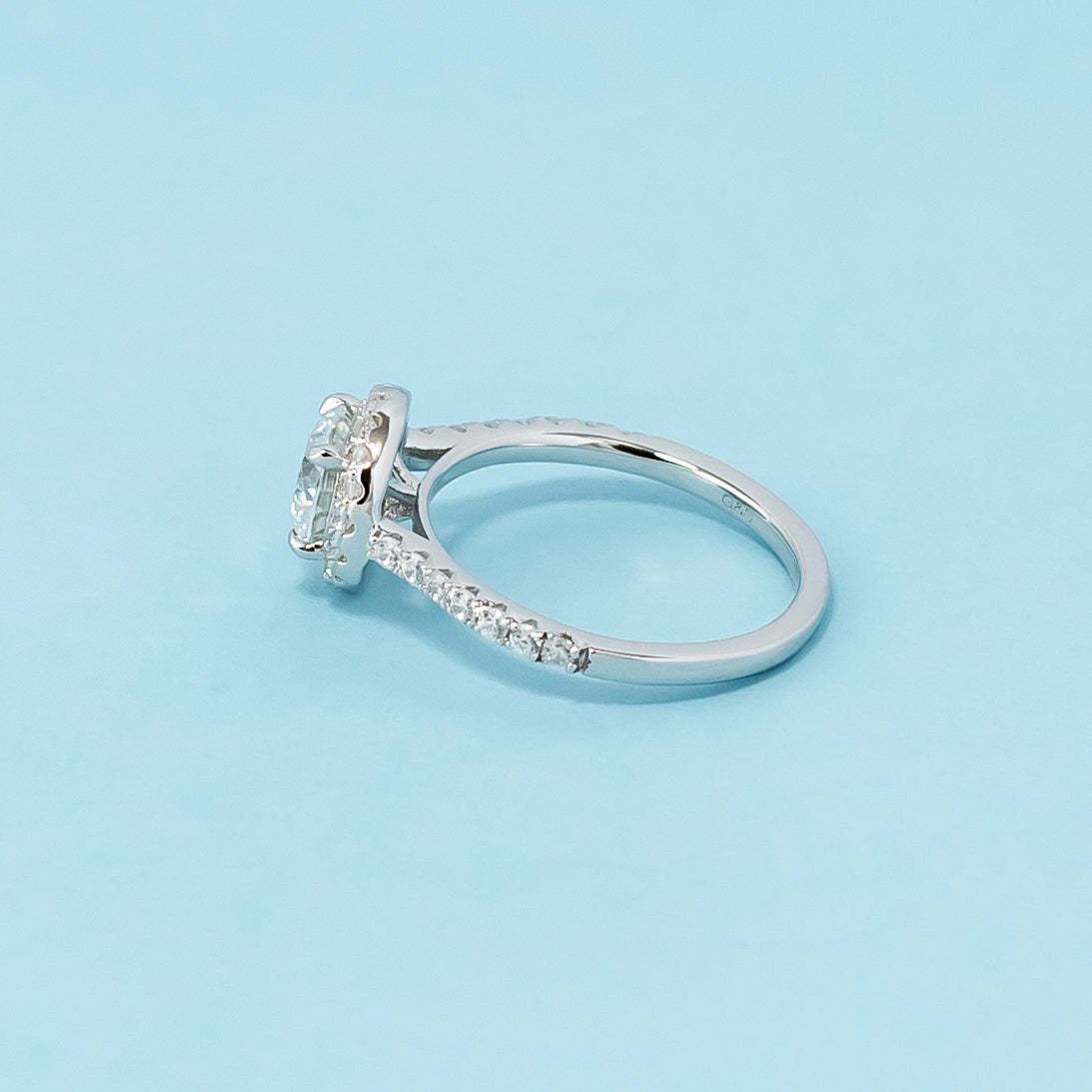 Timeless and sophisticated engagement ring showcasing a round brilliant moissanite in a beautiful halo design, crafted in 9ct white gold.