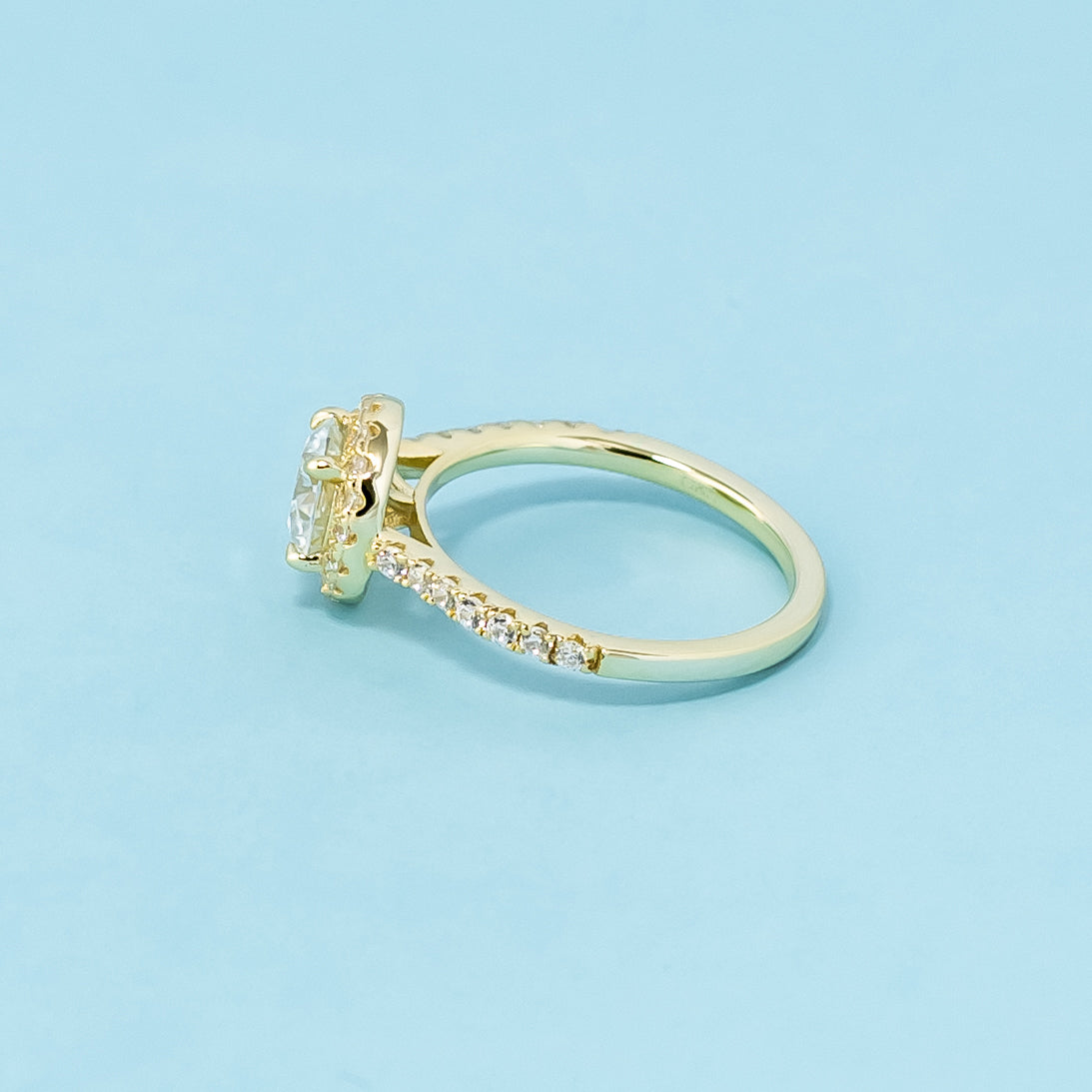  A beautiful halo design accentuates the sparkle of a round brilliant moissanite in this 9ct yellow gold ring.